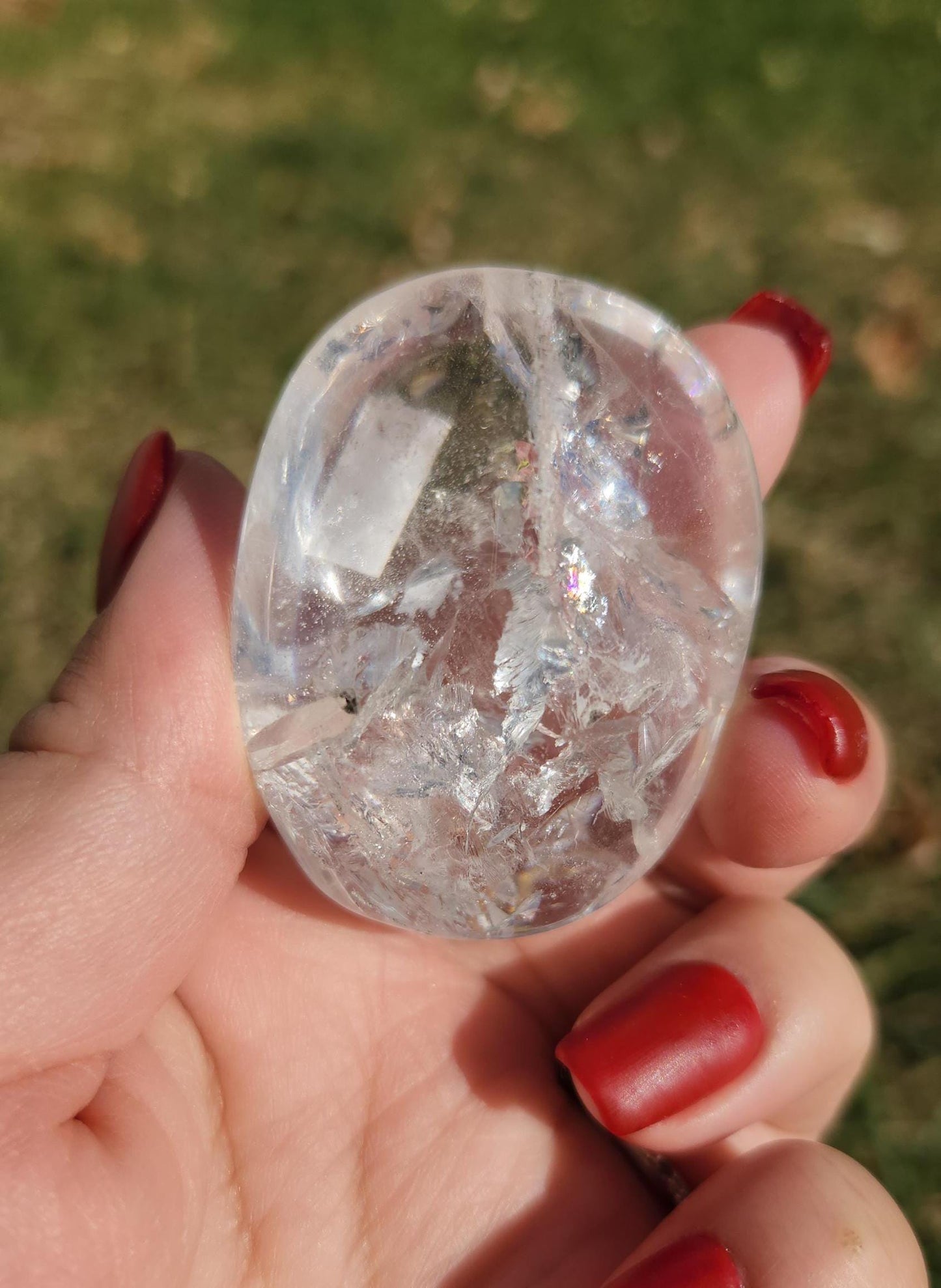 Stunning lemurian clear quartz palm stone with inclusions and shy rainbows, from the Tocantins mine in Brazil