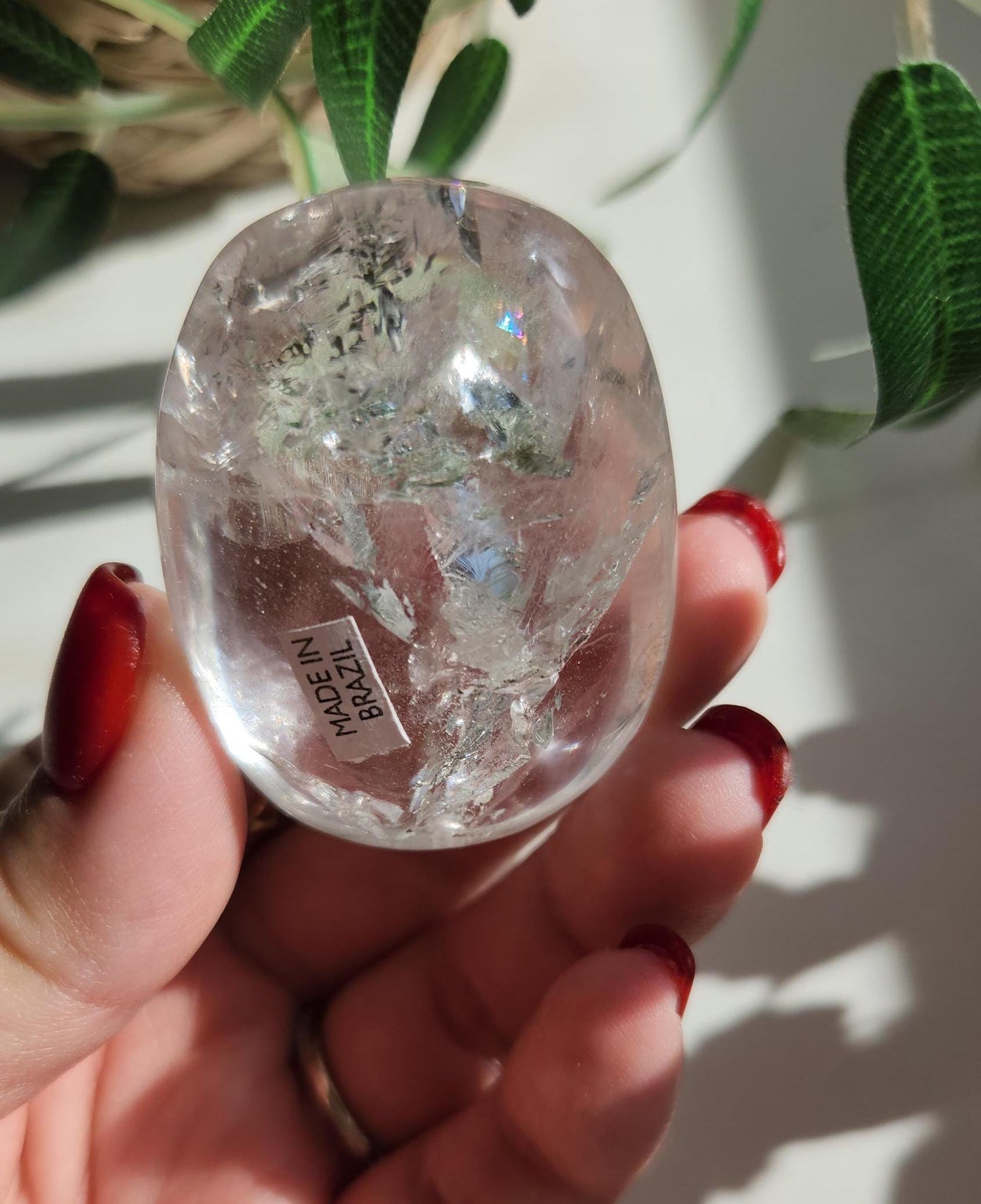 Stunning lemurian clear quartz palm stone with inclusions and shy rainbows, from the Tocantins mine in Brazil