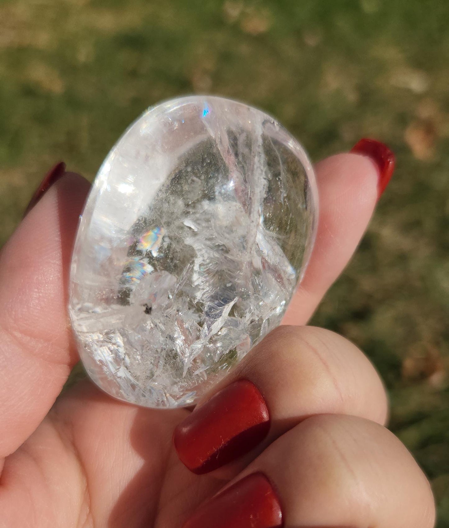Stunning lemurian clear quartz palm stone with inclusions and shy rainbows, from the Tocantins mine in Brazil