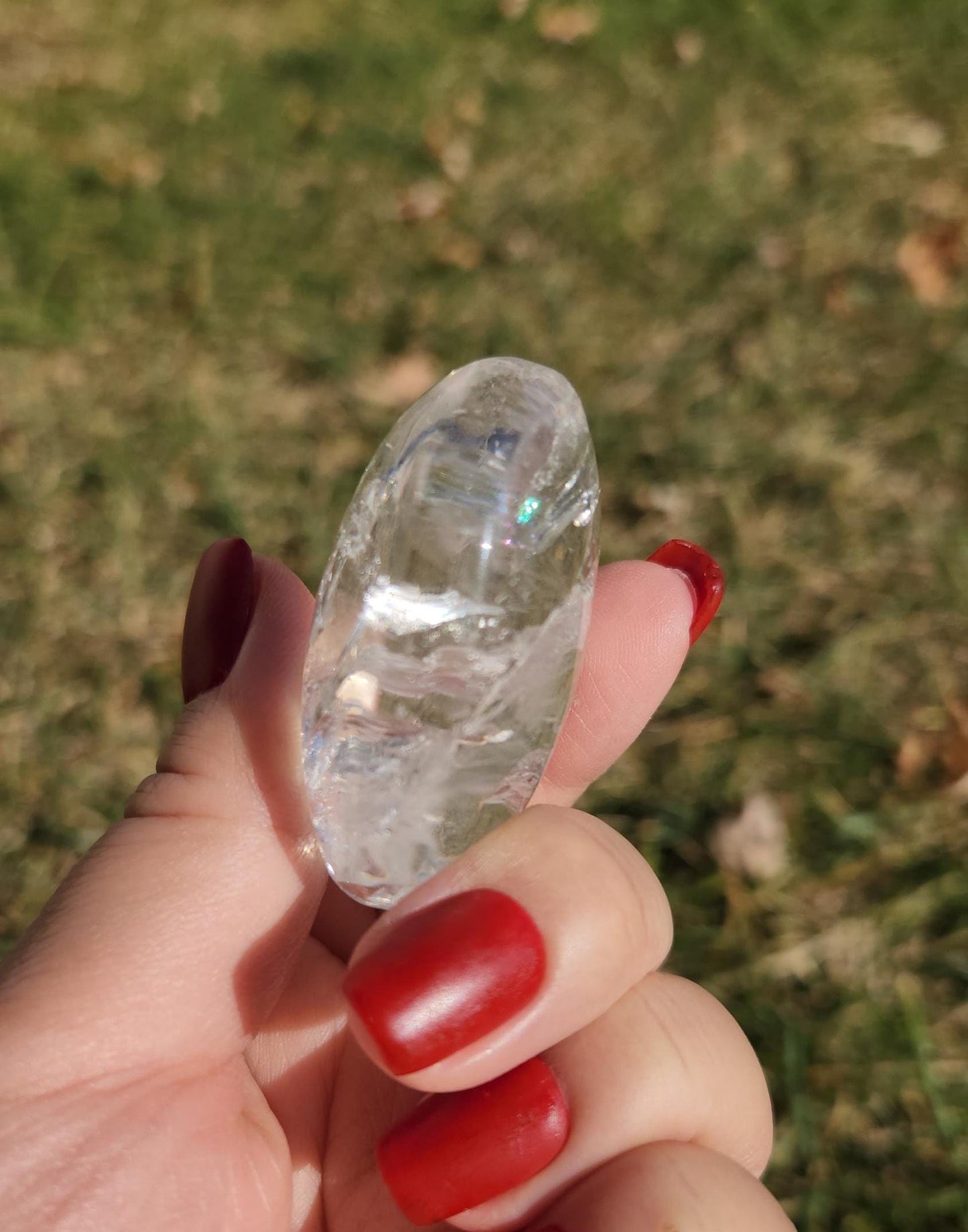 Stunning lemurian clear quartz palm stone with inclusions and shy rainbows, from the Tocantins mine in Brazil