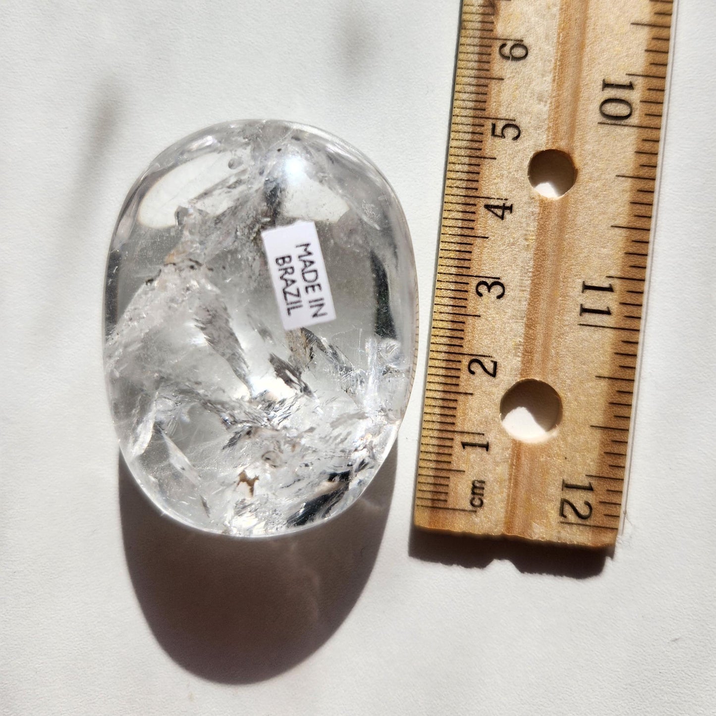 Stunning lemurian clear quartz palm stone with inclusions and shy rainbows, from the Tocantins mine in Brazil