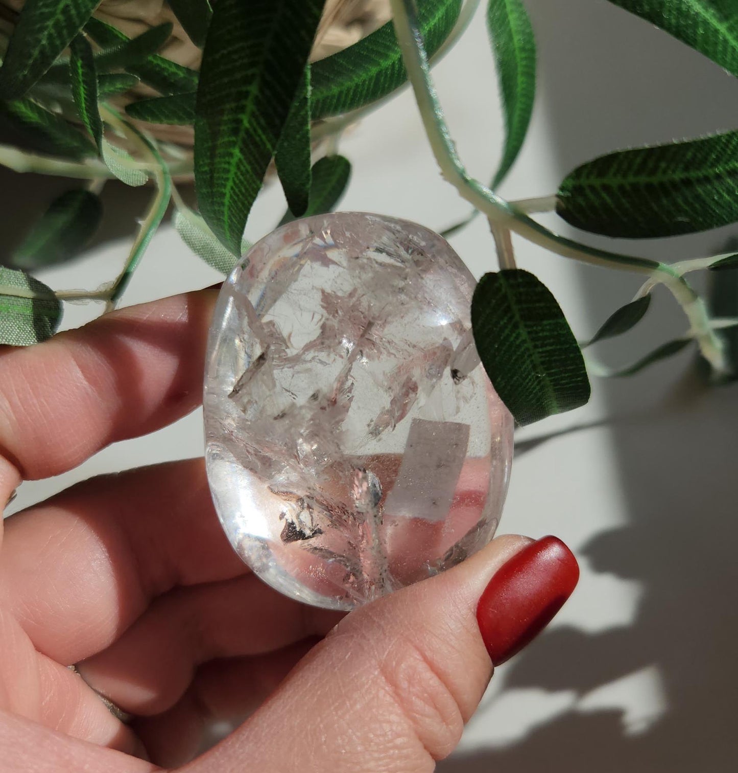 Stunning lemurian clear quartz palm stone with inclusions and shy rainbows, from the Tocantins mine in Brazil