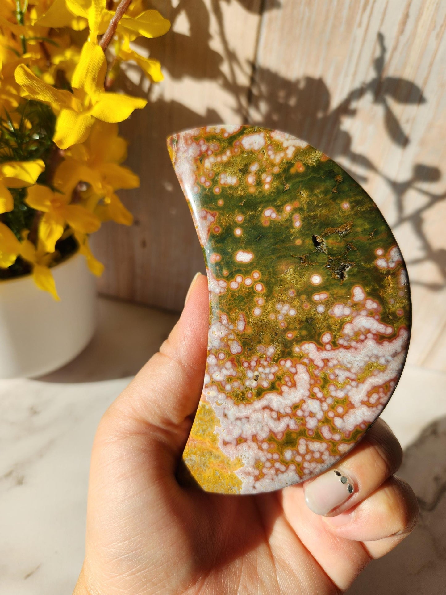 Large pink yellow ocean jasper moon with beautiful colors, patterns, and small sparkly druzy, stand included