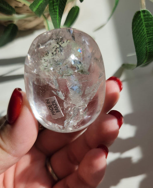 Stunning lemurian clear quartz palm stone with inclusions and shy rainbows, from the Tocantins mine in Brazil