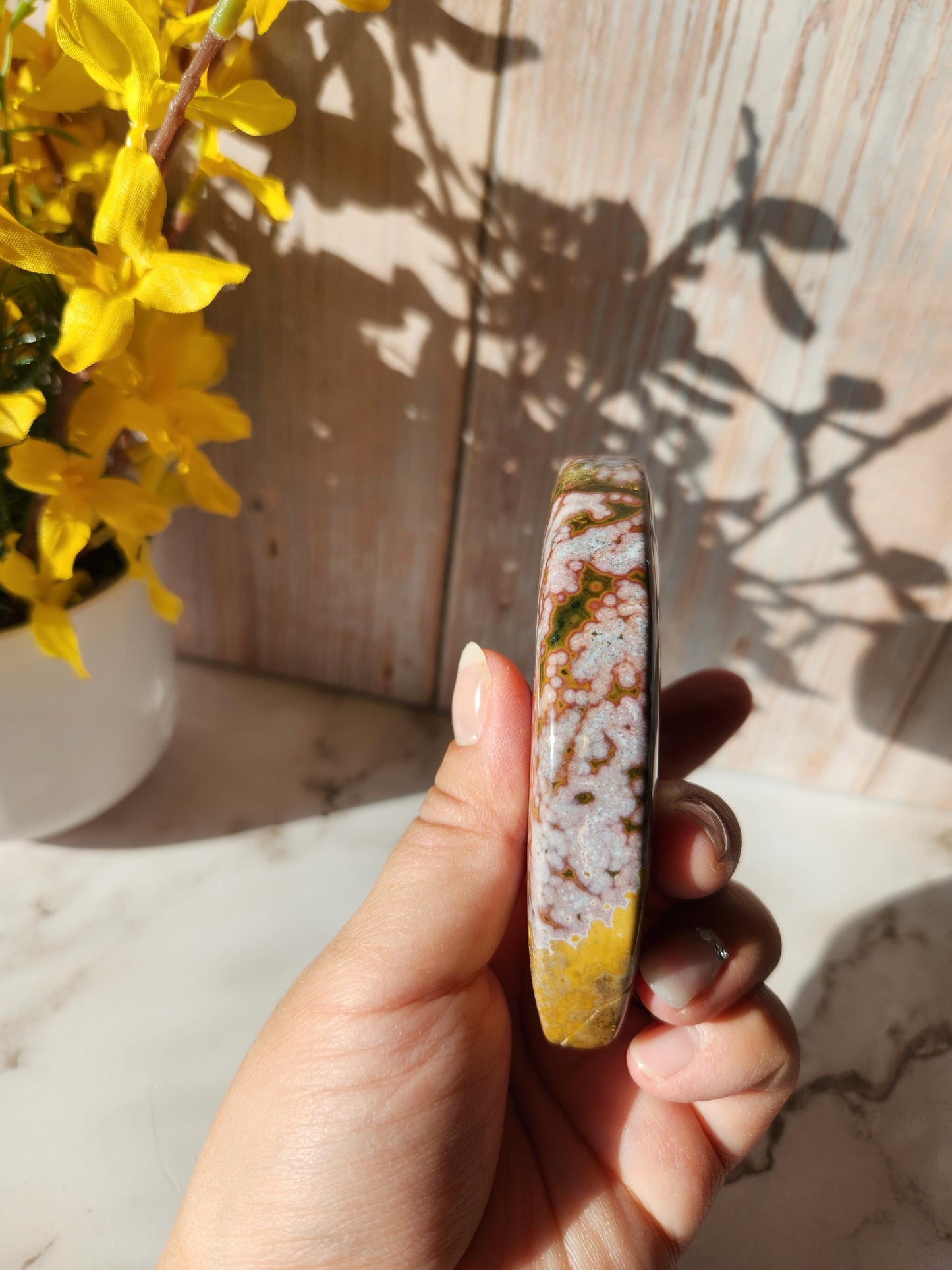Large pink yellow ocean jasper moon with beautiful colors, patterns, and small sparkly druzy, stand included