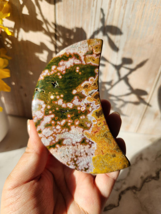 Large pink yellow ocean jasper moon with beautiful colors, patterns, and small sparkly druzy, stand included