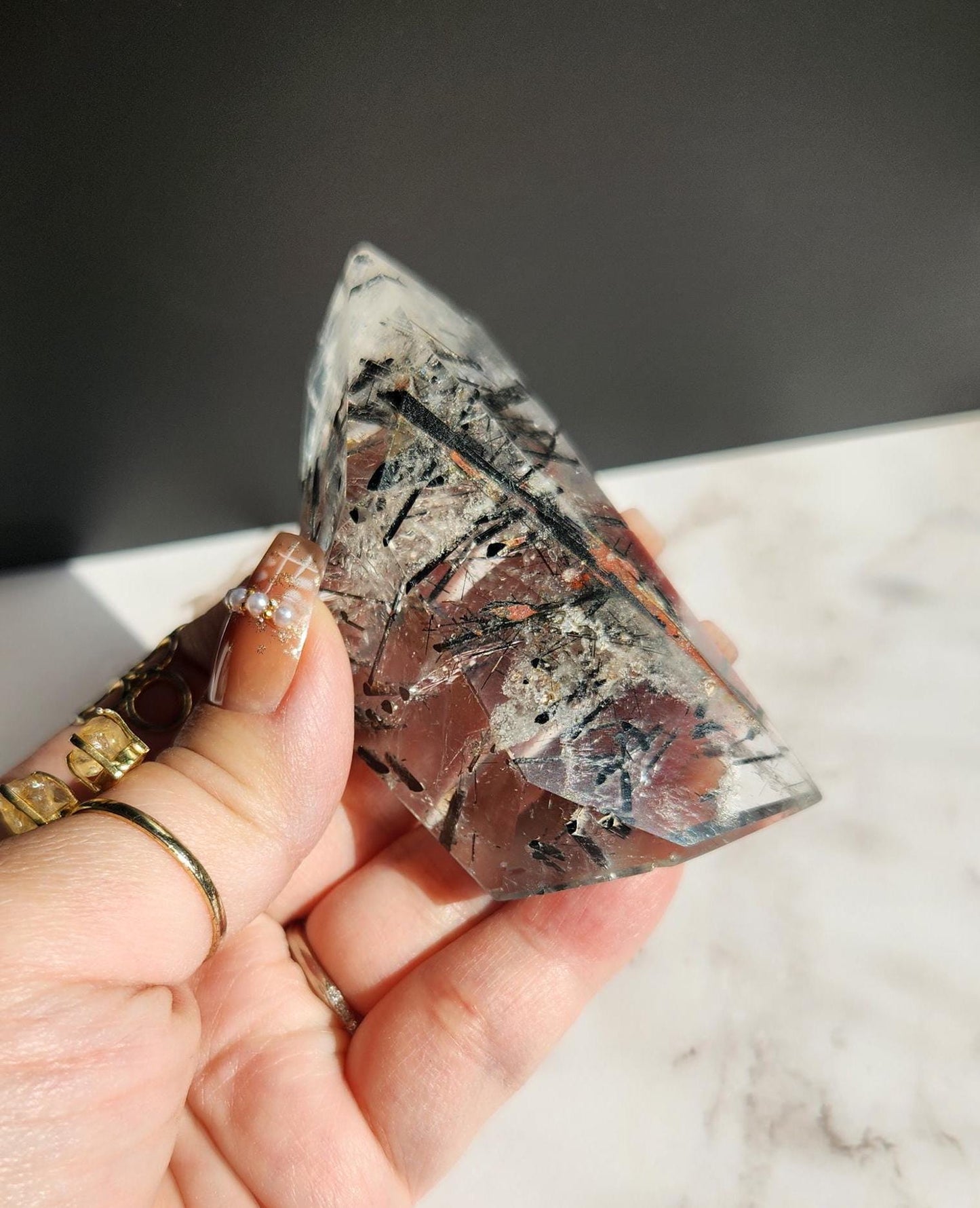 High quality black tourmaline in quartz  freefrom with rainbows on a beautiful gold custom stand